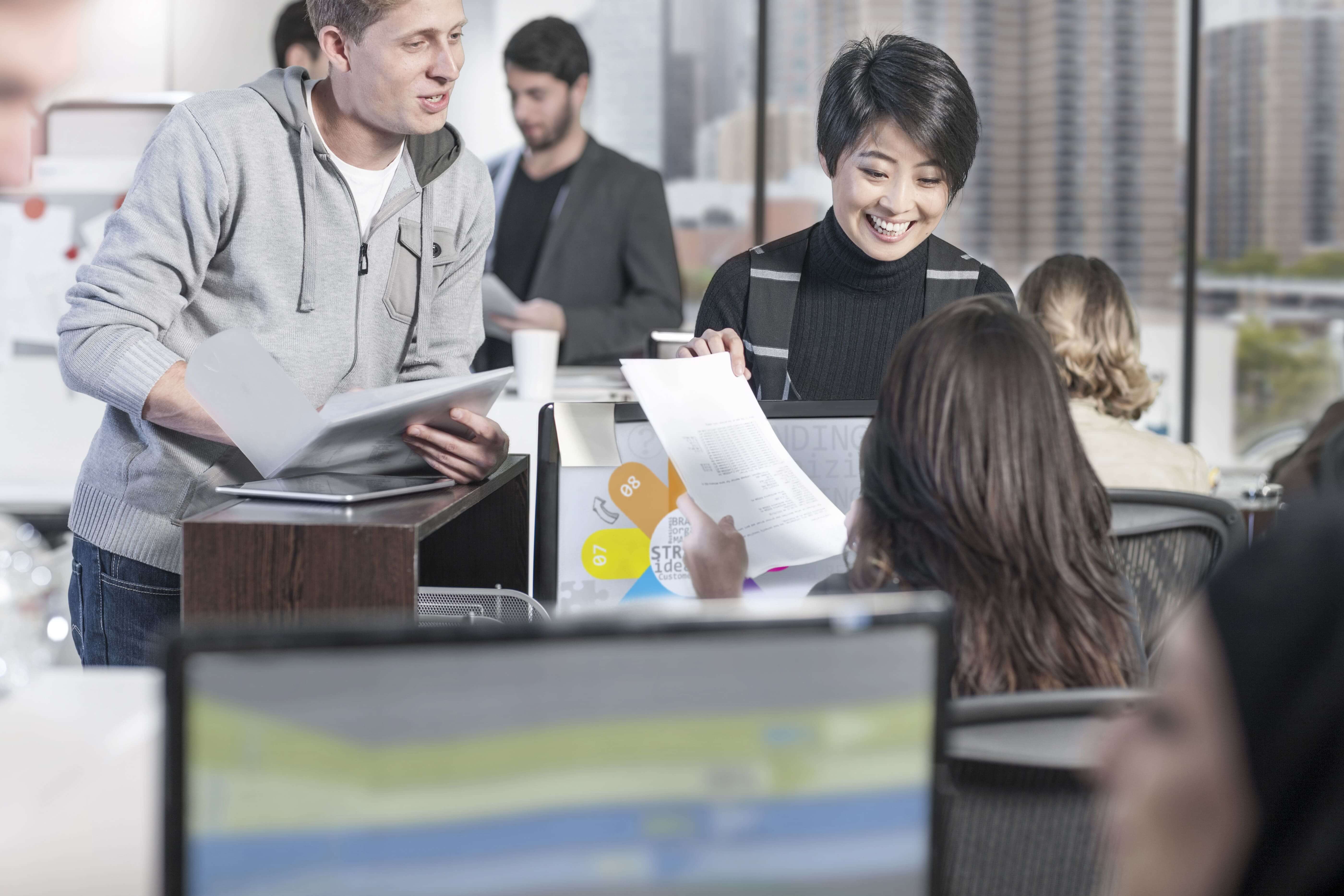Smiling colleagues working together modern office