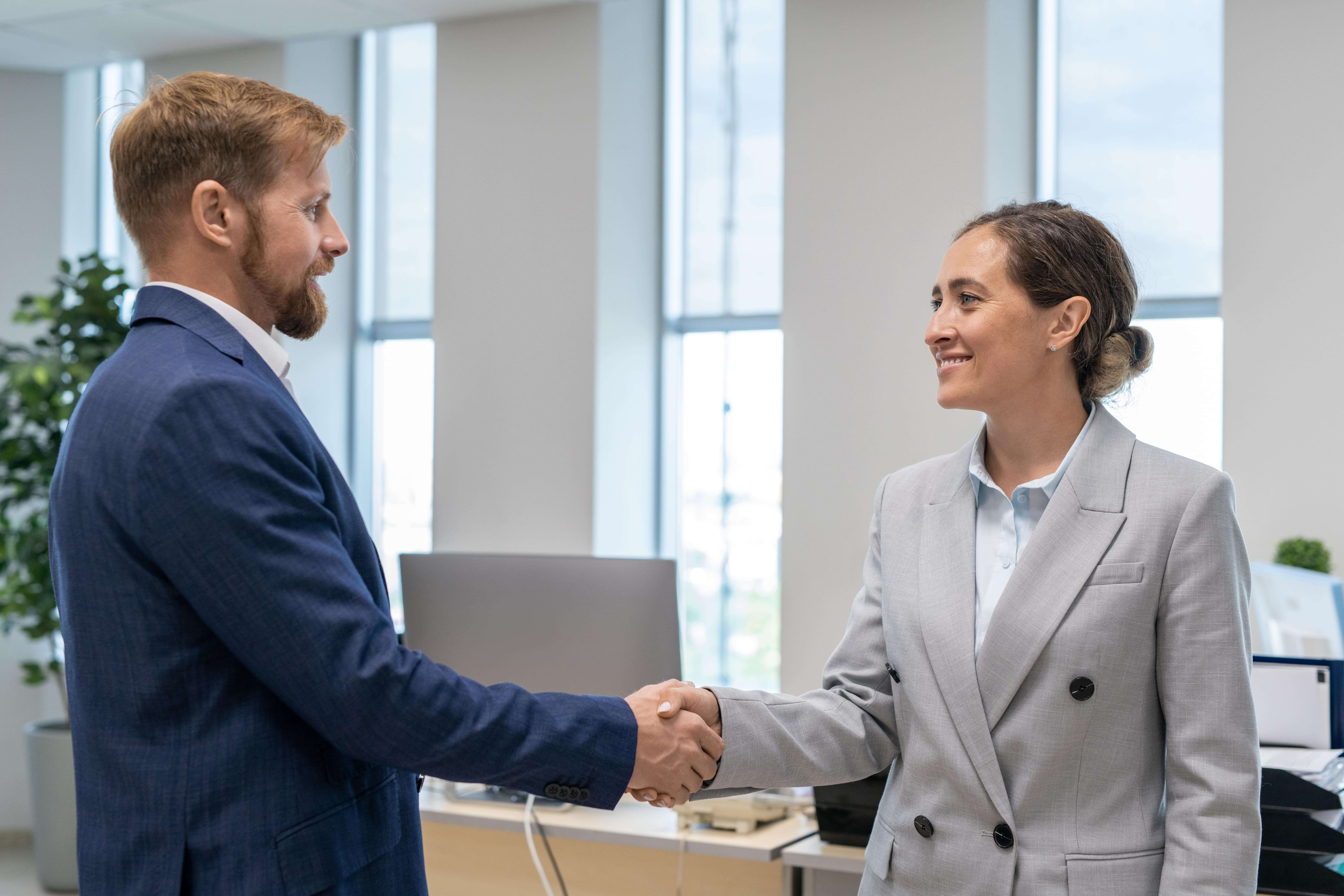 Two happy business partners elegant suits shaking hands