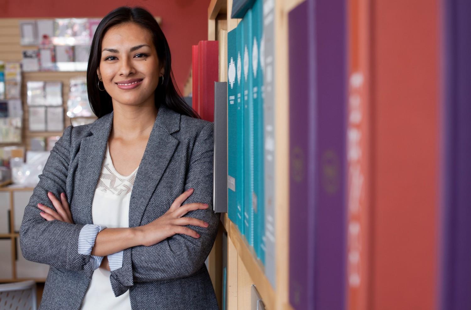 Professional woman leaning on office bookshelf representing agency strategic leadership
