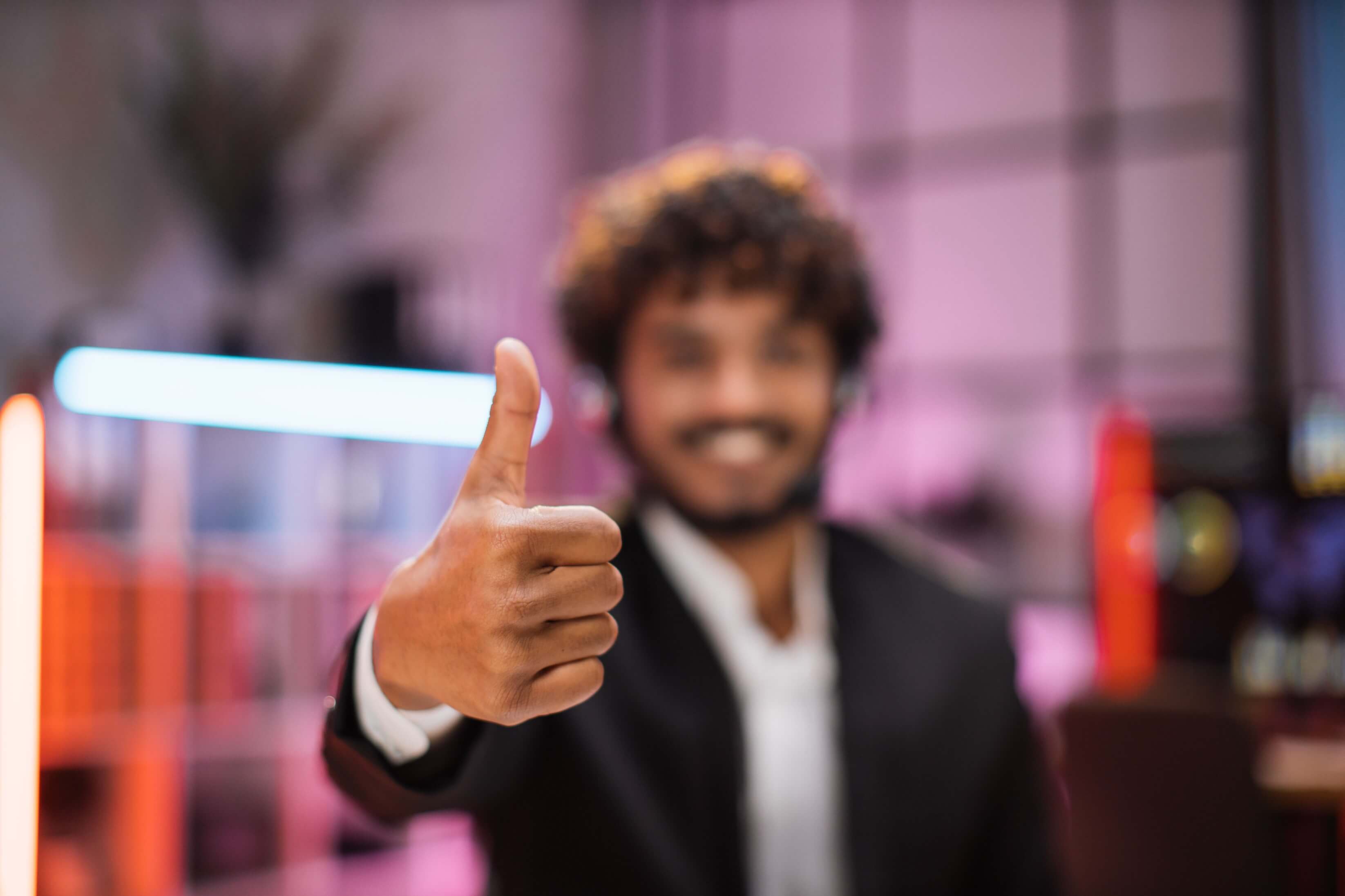 Smiling positive confident man formal wear and headset sitting office desk