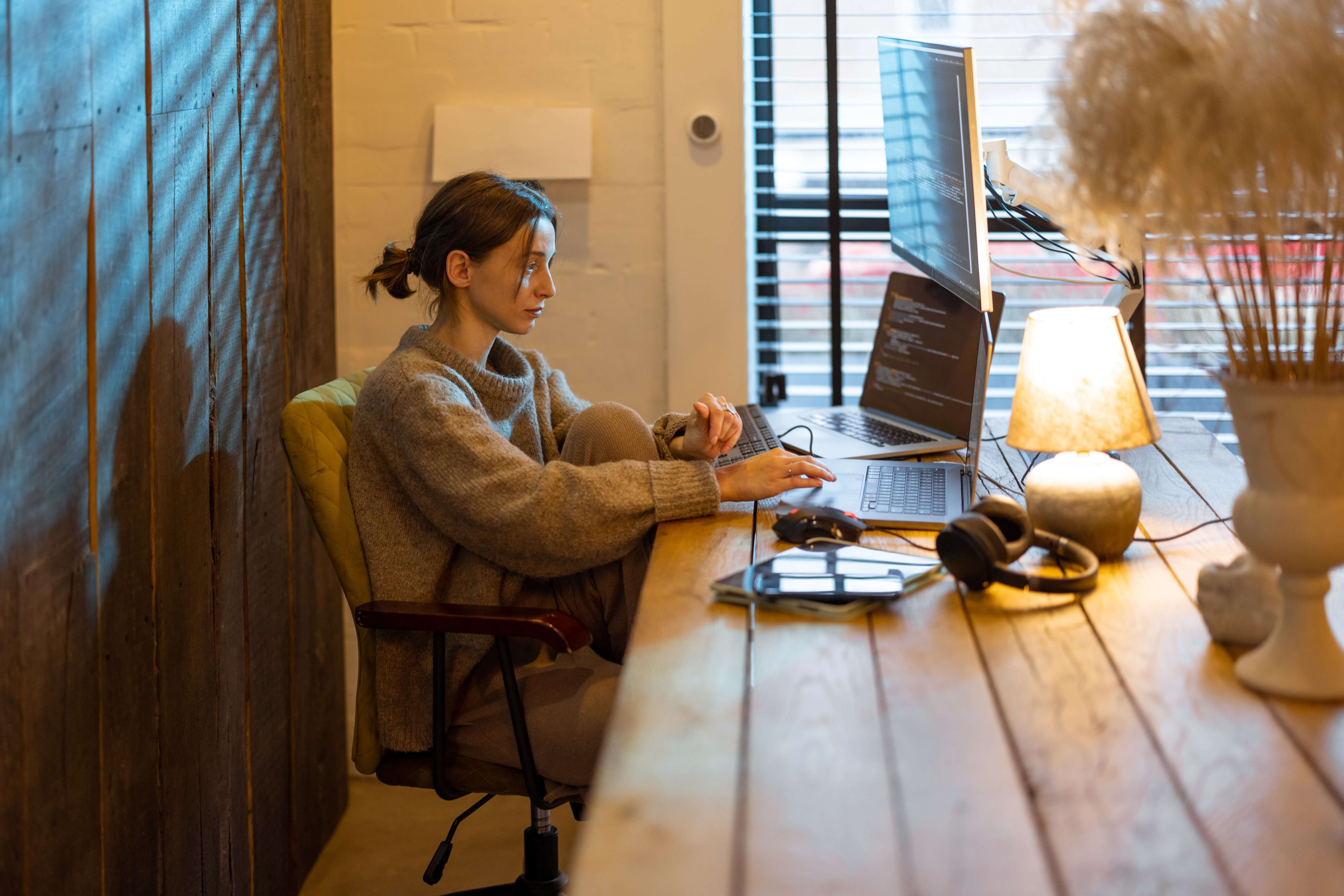 Focused woman coding with dual screens