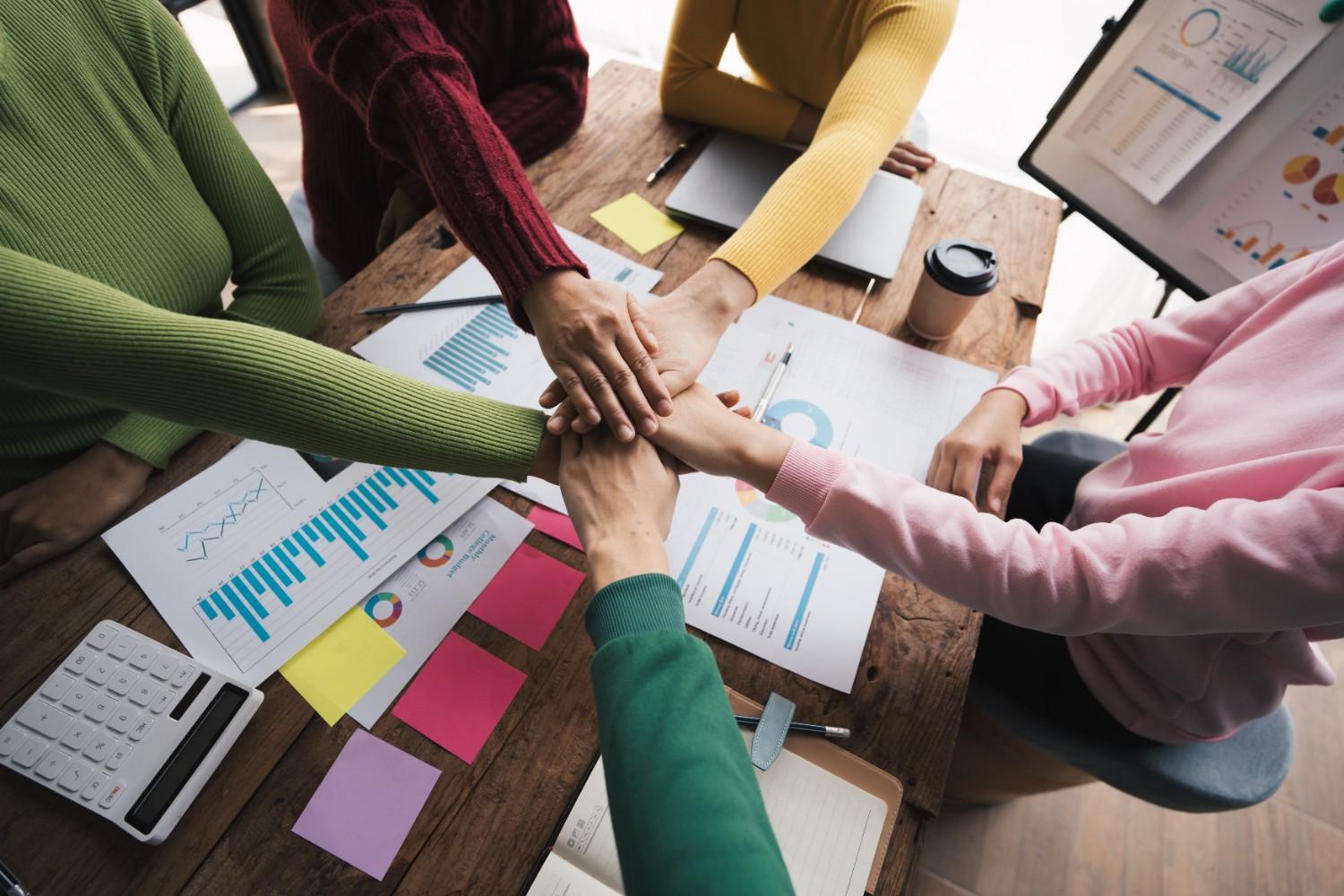 Hands together in collaboration in the office workplace