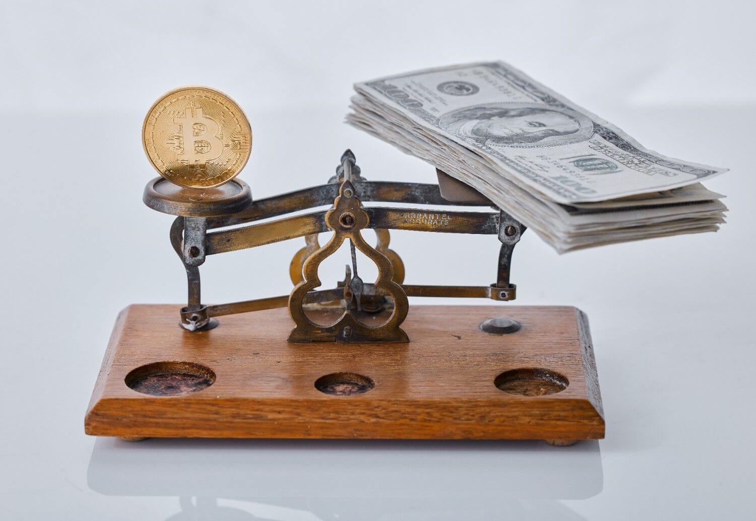 Shot scale balancing coin and wad cash against grey background