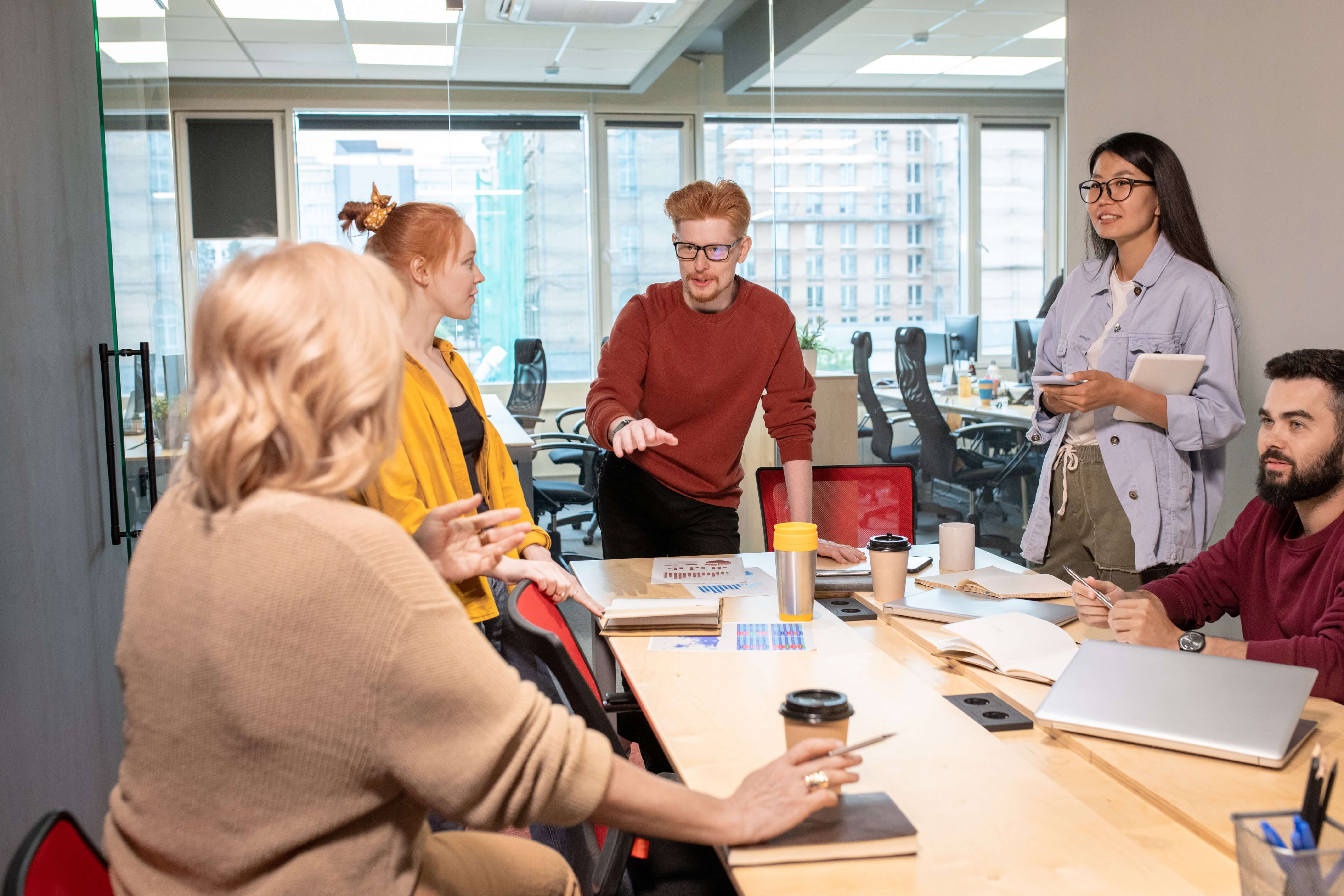 Young confident broker debating with one colleagues explaining her viewpoint