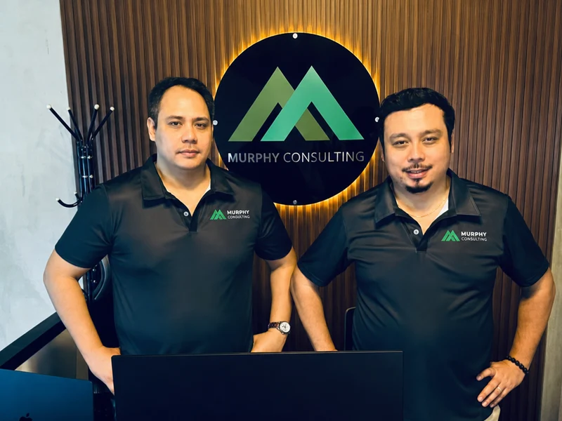 Murphy Consulting staff in front of the Murphy Consulting office logo